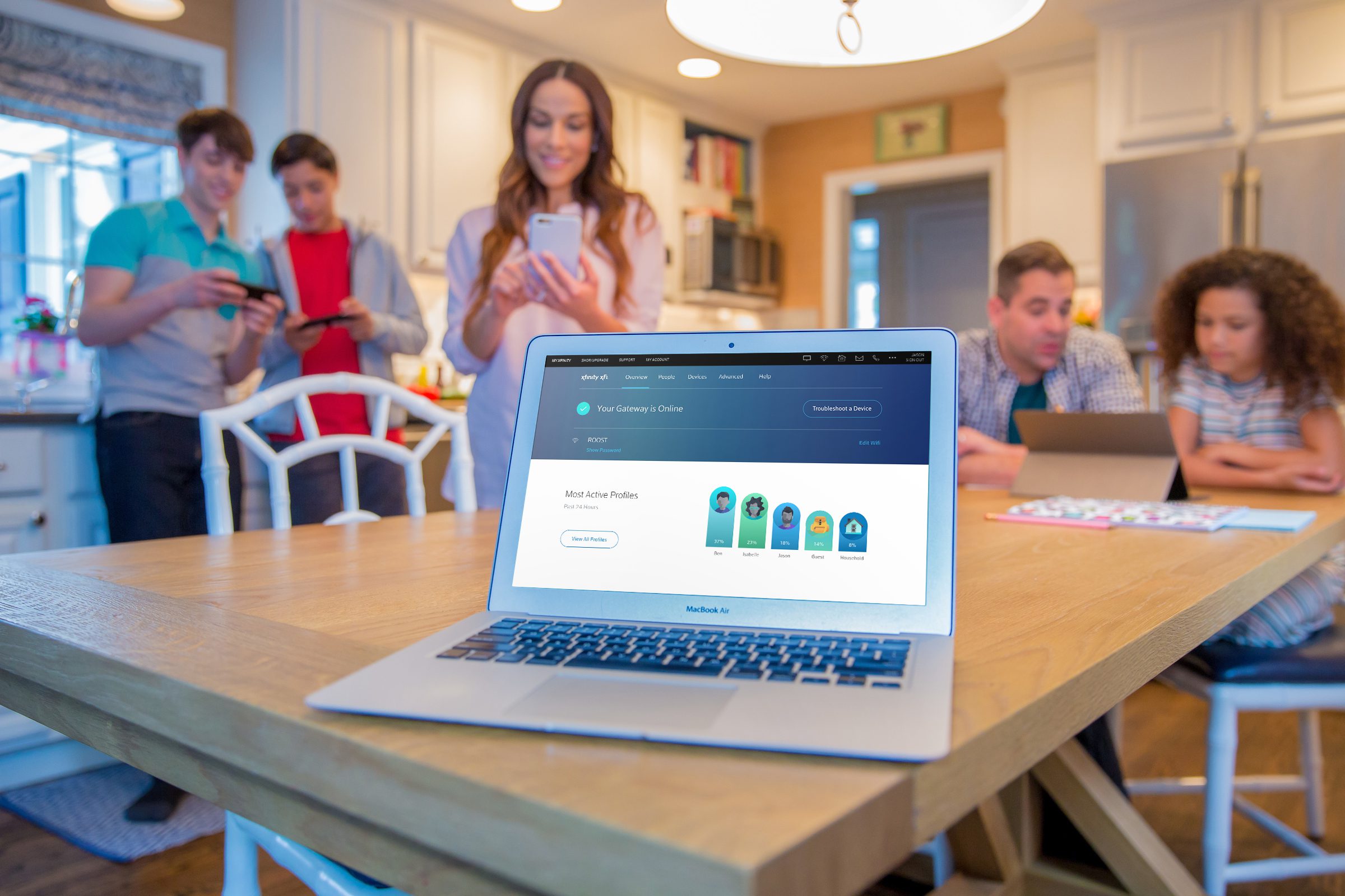 A family is gathered around a laptop displaying the status of their Xfinity xFi devices.