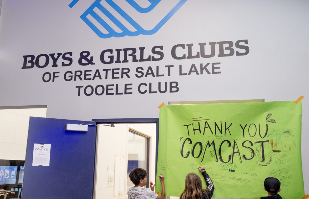 Kids from the Boys & Girls Clubs of Tooele sign a thank you poster for Comcast before the Lift Zone Technology Center Ribbon Cutting ceremony at the Boys & Girls Club of Greater Salt Lake on Wednesday, May 22, 2024 in Tooele, UT. (Kim Raff/Comcast)